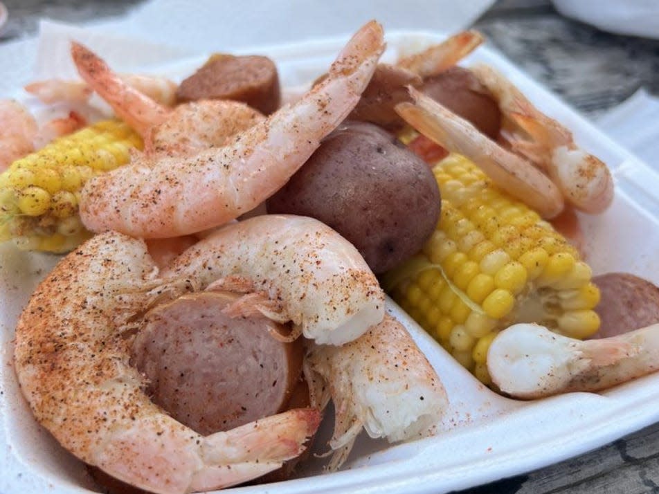 Skully's Low Country Boil shrimp, potatoes, and corn on a white plate