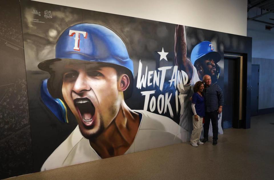 Texas Rangers fans take a photo next to a mural at Globe Life Field on Thursday, March 28, 2024, at Globe Life Field in Arlington. Amanda McCoy/amccoy@star-telegram.com