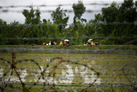 Rohigya refugees are seen through barbed wire waiting for boat to cross the border through the Naf river in Maungdaw, Myanmar, September 7, 2017. REUTERS/Mohammad Ponir Hossain