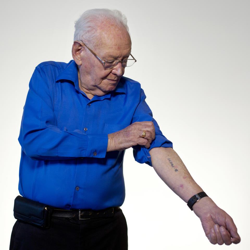 In this photo taken Wednesday, April 9, 2014, Israeli Holocaust survivor Asher Aud (Sieradski), 86, originally from Poland, shows his number tattooed on his arm by the Nazis at the Auschwitz concentration camp as he poses for a portrait in Jerusalem. Of all the atrocities he endured, Aud said the strongest memory is the one that was most traumatic _ parting from his mother at the age of 14. It was September 1942. The Nazis had rounded up the Jewish community inside the local cemetery and were preparing to deport them. His father and older brother had already been taken and he was left with his mother and younger brother, Gavriel."I remember looking down and I happened to be standing on my grandmother's tombstone," he recalled. "The Germans walked among us and anytime they saw a mother with a child, they tore the child from her arms and threw them into the back of trucks." That's when he realized life as he knew it was over." I looked around and I just said 'mother, this is where we are going to be separated,'" he said. (AP Photo/Sebastian Scheiner)