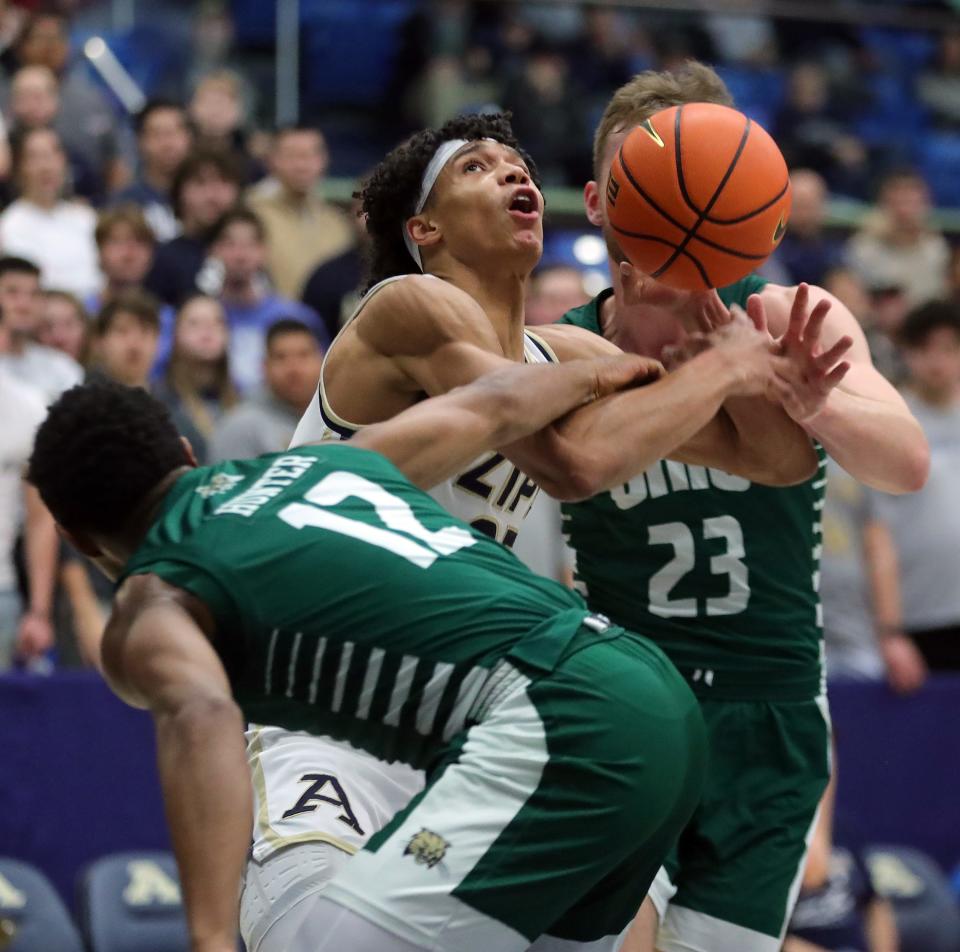 Akron Zips forward Enrique Freeman is fouled by Ohio guard Jaylin Hunter (12) during the first half, Tuesday, Jan. 23, 2024.