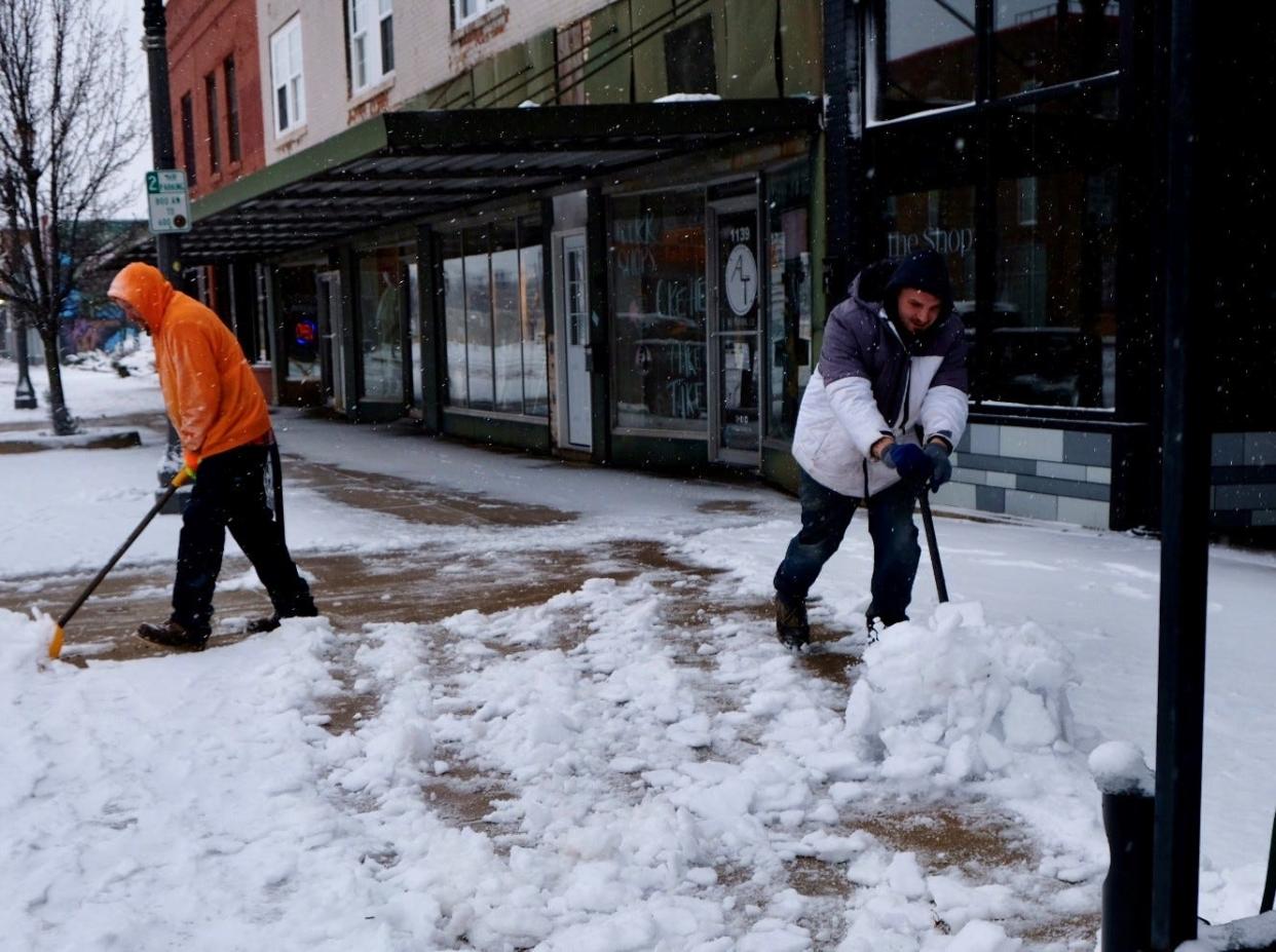 Josh Jenks, left, and Israel Demoya clear sidewalks of snow in Lansing’s REO Town on Saturday, Jan. 13, 2024.