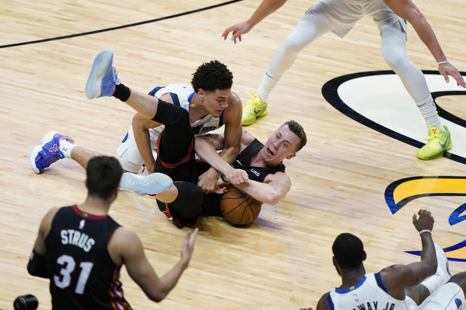 Miami Heat forward Duncan Robinson, right, and Dallas Mavericks guard Josh Green (8) battle for a loose ball during the first half of an NBA basketball game, Tuesday, May 4, 2021, in Miami. (AP Photo/Wilfredo Lee)