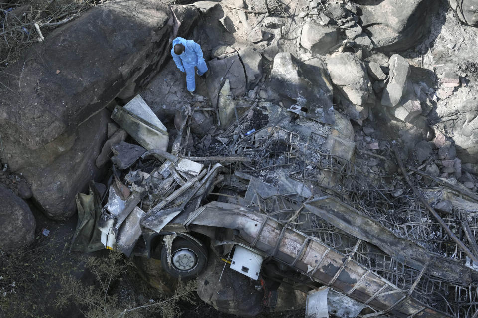 The wreckage of a bus lays in a ravine a day after it plunged off a bridge on the Mmamatlakala mountain pass between Mokopane and Marken, around 300km (190 miles) north of Johannesburg, South Africa, Friday, March 29, 2024. The bus carrying worshippers on a long-distance trip from Botswana to an Easter weekend church gathering in South Africa plunged off a bridge on a mountain pass Thursday and burst into flames as it hit the rocky ground below, killing at least 45 people, authorities said. The only survivor was an 8-year-old child who was receiving medical attention for serious injuries. (AP Photo/Themba Hadebe)