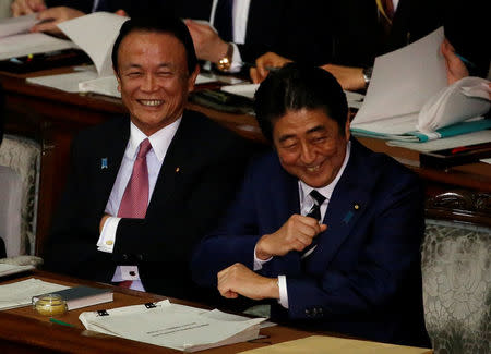 Japan's Prime Minister Shinzo Abe (R) and Deputy Prime Minister and Finance Minister Taro Aso attend the ordinary session of parliament in Tokyo, Japan, January 20, 2017. REUTERS/Toru Hanai