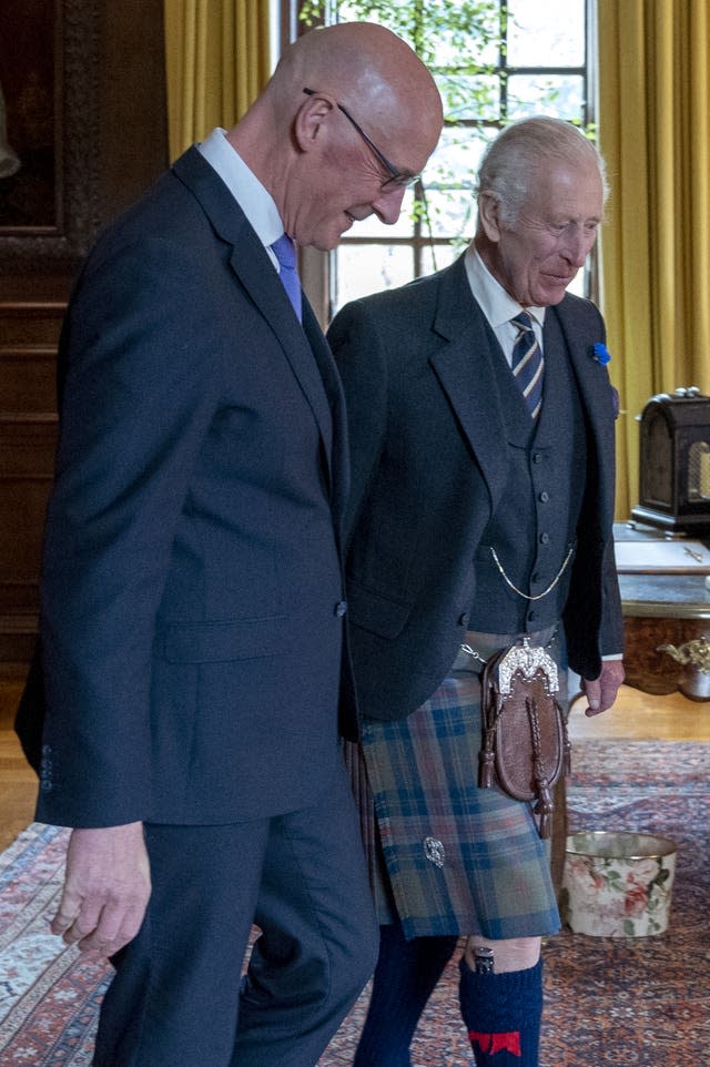 The King and SNP leader walking across the room together at the Palace of Holyroodhouse 