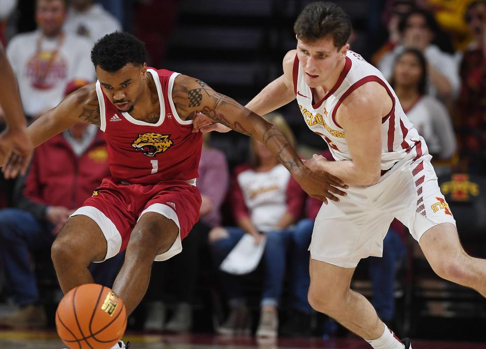 Iowa State University Cyclones guard Caleb Grill (2)  and IUPUI Jaguars guard Vincent Brady II (1) battle for the lose ball during the first half in the season opening home game at Hilton Coliseum Monday, Nov. 7, 2022, in Ames, Iowa.  Photo by Nirmalendu Majumdar/Ames Tribune