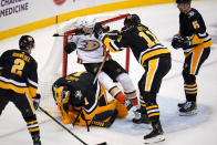 Pittsburgh Penguins goaltender Casey DeSmith (1) covers the puck as Brian Boyle (11) checks Anaheim Ducks' Rickard Rakell (67) into the goal cage during the third period of an NHL hockey game in Pittsburgh, Saturday, Dec. 11, 2021. The Penguins won 1-0. (AP Photo/Gene J. Puskar)