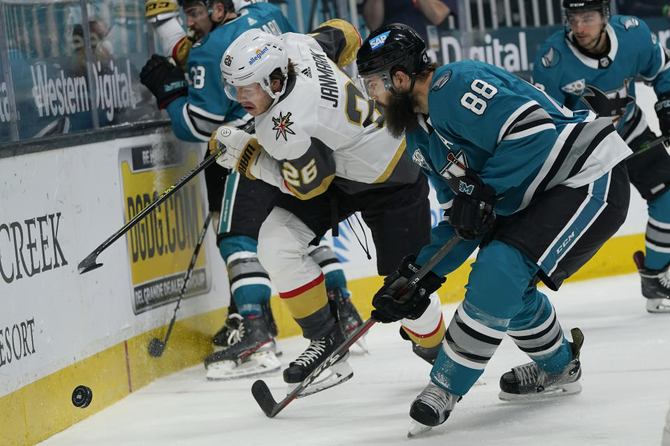 Vegas Golden Knights center Mattias Janmark (26) and San Jose Sharks defenseman Brent Burns (88) skate toward the puck during the second period of an NHL hockey game in San Jose, Calif., Wednesday, May 12, 2021. (AP Photo/Jeff Chiu)