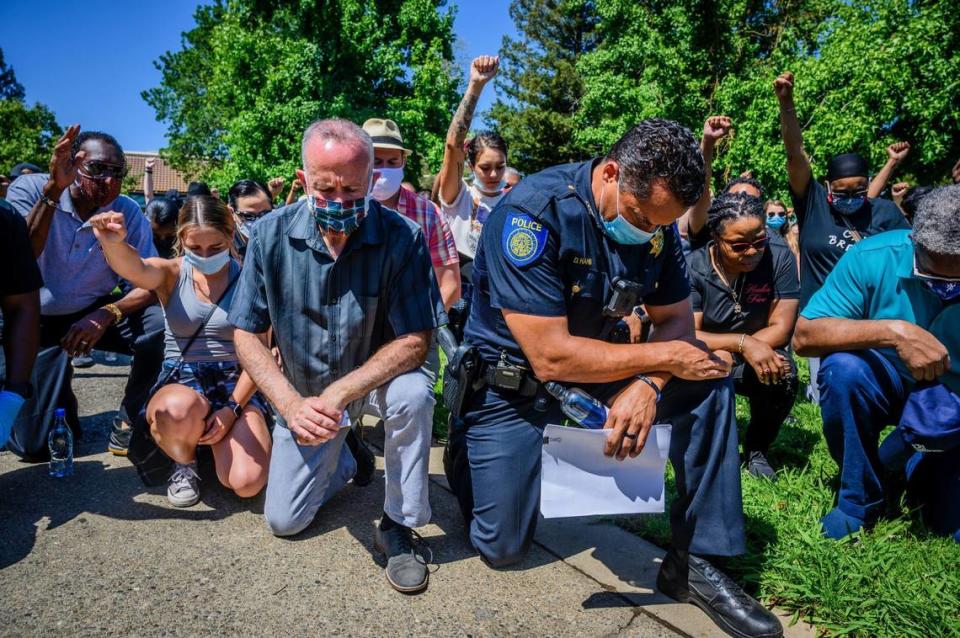 Mayor Darrell Steinberg and Police Chief Daniel Hahn kneel with a large group of demonstrators in Sacramento’s Oak Park neighborhood in June 2020 in a display of unity as another day of protests over the death of George Floyd was planned in Sacramento. Daniel Kim/Sacramento Bee file