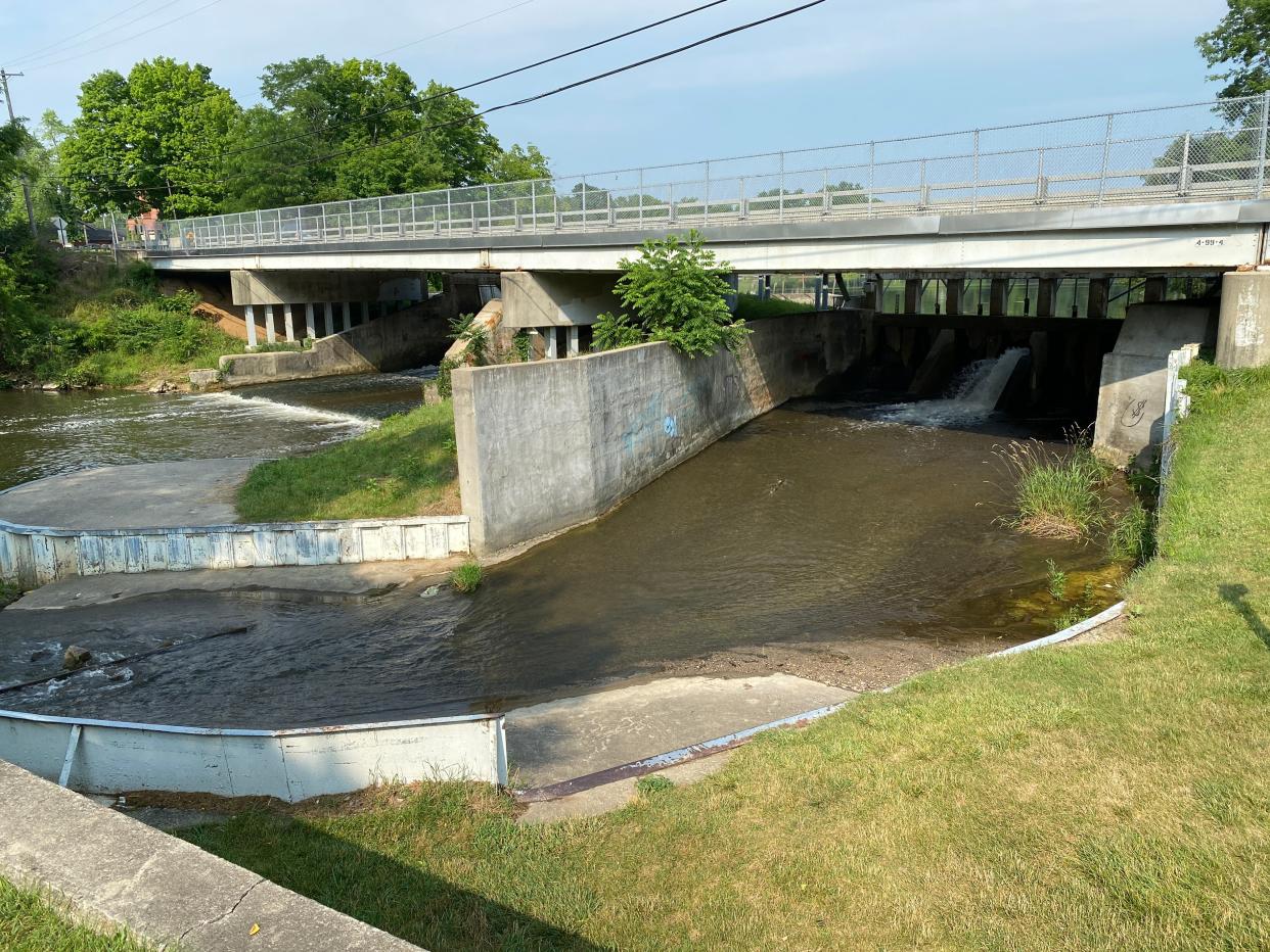 The Red Mill Pond dam in Tecumseh is pictured Thursday. The Lenawee County Drain Commissioner's Office is preparing a repair and realignment project for the dam's auxiliary spillway, which is in the foreground. Along with that project, the county has asked the Tecumseh City Council if it would fund a $161,000 project to create a proper kayak and canoe portage around the south end of the dam, which is at the far left of the photo. Watercraft users already have carved a path at that end of the dam between the pond and the River Raisin.