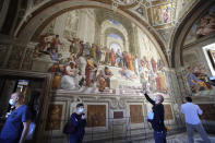 Visitors admire "The School of Athens" fresco by Italian Renaissance artist Raphael inside the Vatican Museum after it reopened, in Rome, Monday, June 1, 2020. The Vatican Museums reopened Monday to visitors after three months of shutdown following COVID-19 containment measures. (AP Photo/Alessandra Tarantino)