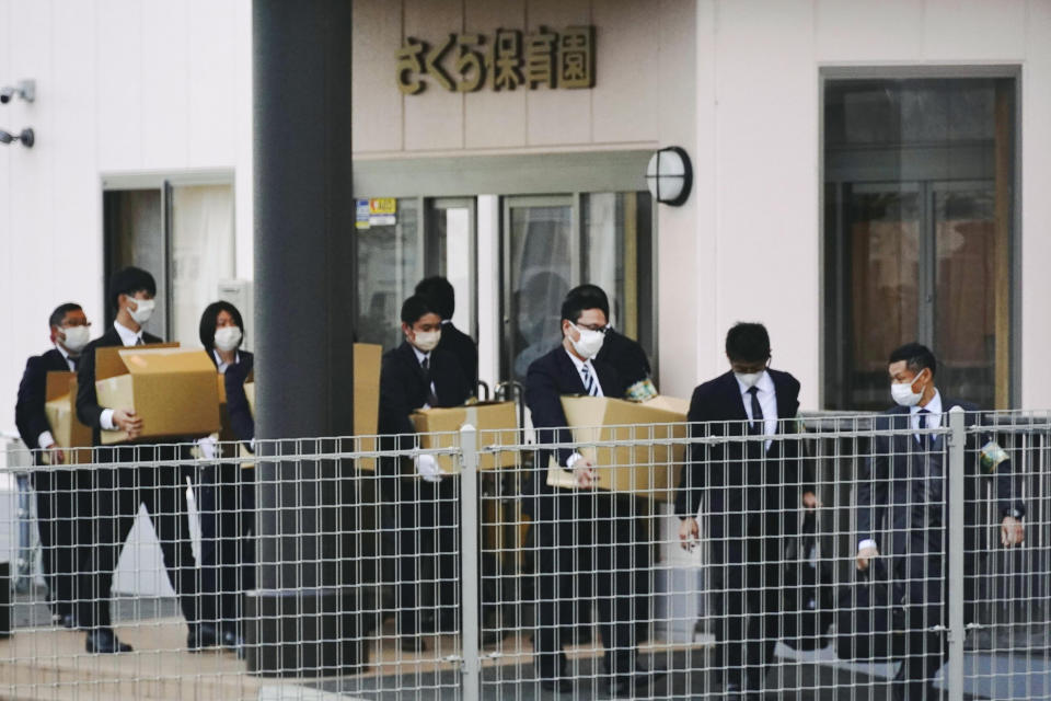 Police investigators carry boxes of documents out of Sakura nursery school in Susono city, Shizuoka, central Japan, Sunday, Dec. 4, 2022. Japanese police said Monday, Dec. 5, that they have arrested three teachers at the nursery school in central Japan on suspicion they routinely abused toddlers, such as hitting their heads, holding them upside down and locking them up in a bathroom, a case that triggered outrage across the nation. (Kyodo News via AP)