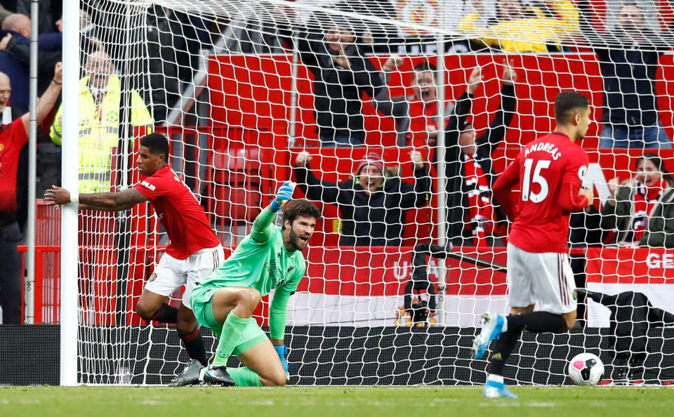 Manchester United's Marcus Rashford (left) scores his side's first goal of the game as Liverpool goalkeeper Alisson (centre) appeals during the Premier League match at Old Trafford, Manchester. (Photo by Martin Rickett/PA Images via Getty Images)