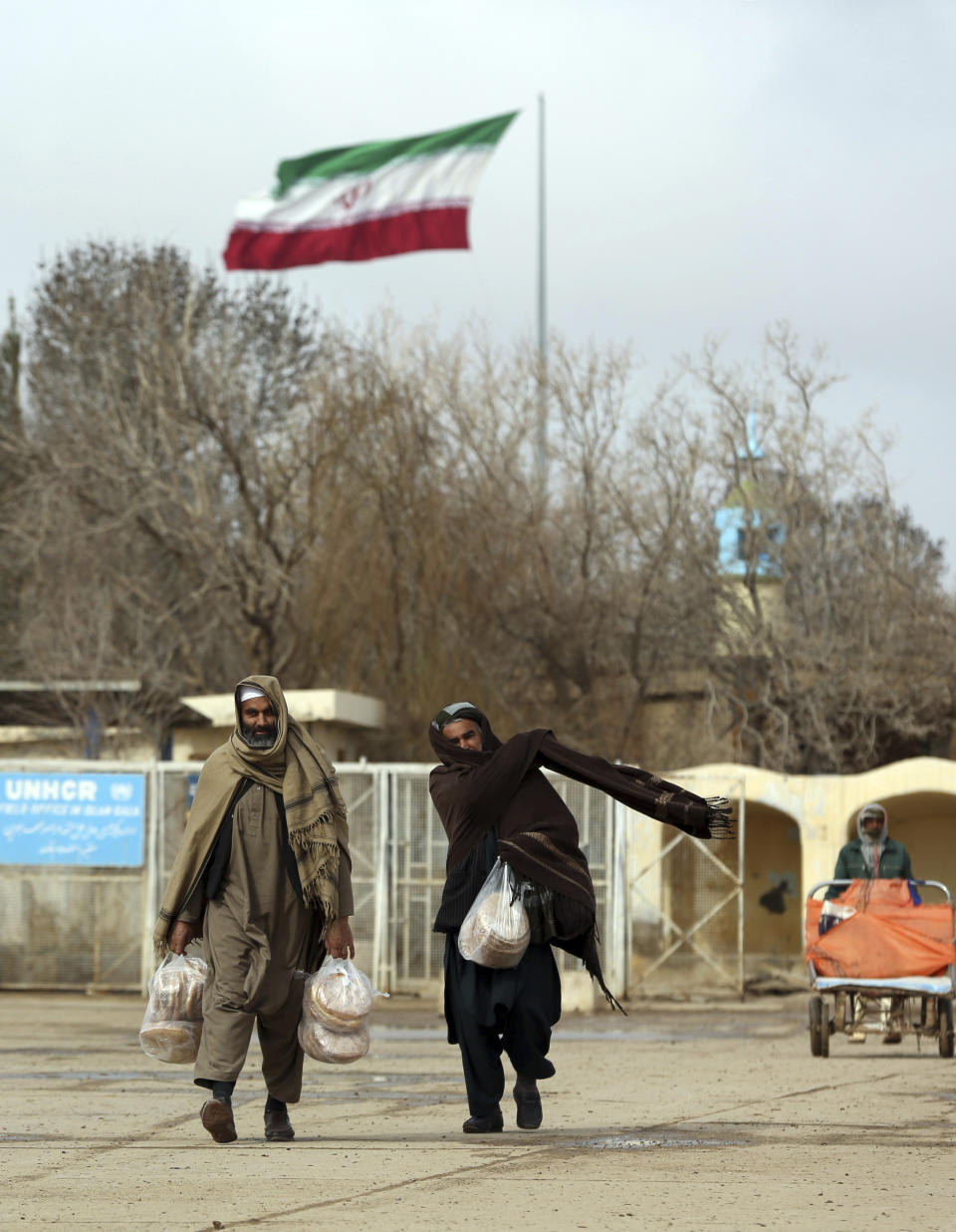 In this Feb. 20, 2019 photo, Afghans return to Afghanistan at the Islam Qala border with Iran, in the western Herat Province. Security officials worry that Iranian-backed Afghan veterans of the war in Syria will one day become a secret army for Tehran in Afghanistan itself, particularly after a U.S. withdrawal. Iran paid, trained and armed thousands of Afghan Shiites to fight in Syria to defend its ally, President Bashar Assad. Returning home as Syria’s war winds down, they face suspicion and fear. (AP Photo/Rahmat Gul)