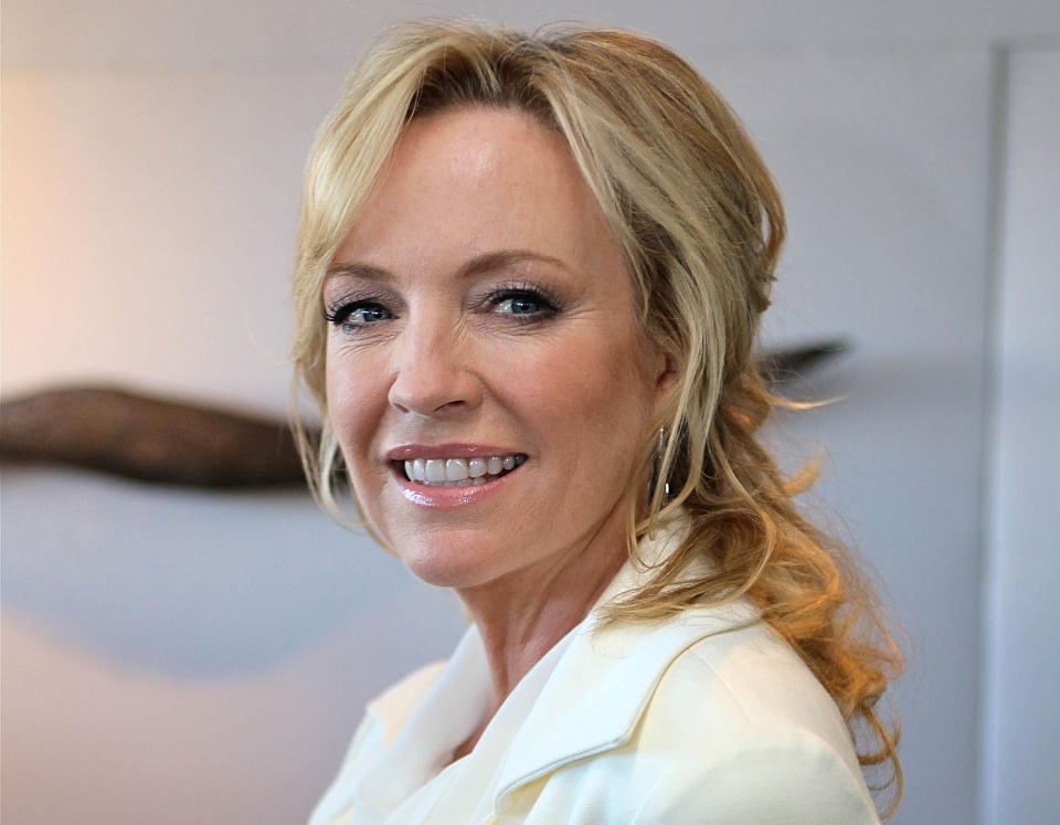 Australian actress Rebecca Gibney poses in white suit and ponytail 