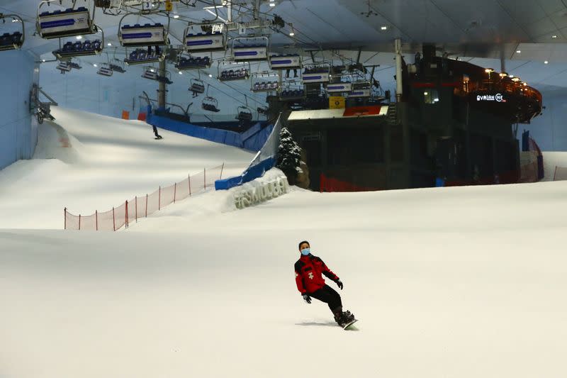 A woman wears a protective face mask as she snowboards at Ski Dubai during the reopening of malls, following the outbreak of the coronavirus disease (COVID-19), at Mall of the Emirates in Dubai