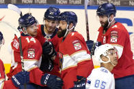 Florida Panthers center Alex Wennberg (21) is congratulated by left wing Grigori Denisenko (14), defenseman Radko Gudas (7) and defenseman Keith Yandle (3) after scoring a goal during the third period of an NHL hockey game against the Tampa Bay Lightning, Monday, May 10, 2021, in Sunrise, Fla. (AP Photo/Lynne Sladky)