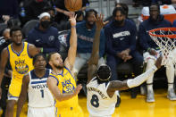 Golden State Warriors guard Stephen Curry (30) shoots between Minnesota Timberwolves forward Anthony Edwards (1) and forward Jarred Vanderbilt (8) during the second half of an NBA basketball game in San Francisco, Thursday, Jan. 27, 2022. (AP Photo/Jeff Chiu)