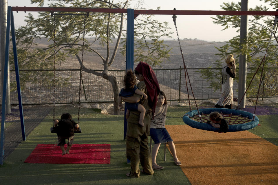Women and their children gather in the playground at the end of the day in the settlement outpost of Asa'el in the south Hebron hills on Monday, Sept. 4, 2023. The outpost, which received legal approval last Wednesday, is home to 90 families, including Israel's Minister of Finance Bezalel Smotrich's brother, Tuvia. (AP Photo/Maya Alleruzzo)