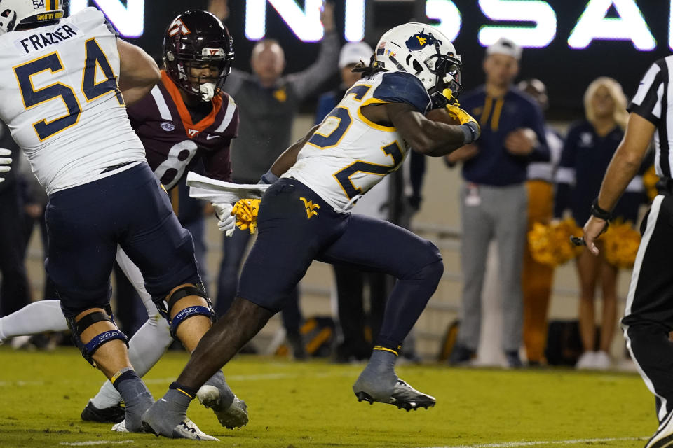 West Virginia running back Justin Johnson Jr. (26) scores a touchdown during the second half of the team's NCAA college football game against Virginia Tech on Thursday, Sept. 22, 2022, in Blacksburg, Va. West Virginia won 33-10. (AP Photo/Steve Helber)