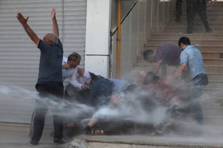 Police use a water cannon to disperse demonstrators during a protest against the replacement of Kurdish mayors with state officials in three cities, in Diyarbakir