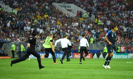 Soccer Football - World Cup - Final - France v Croatia - Luzhniki Stadium, Moscow, Russia - July 15, 2018 Stewards chase a pitch invader REUTERS/Dylan Martinez