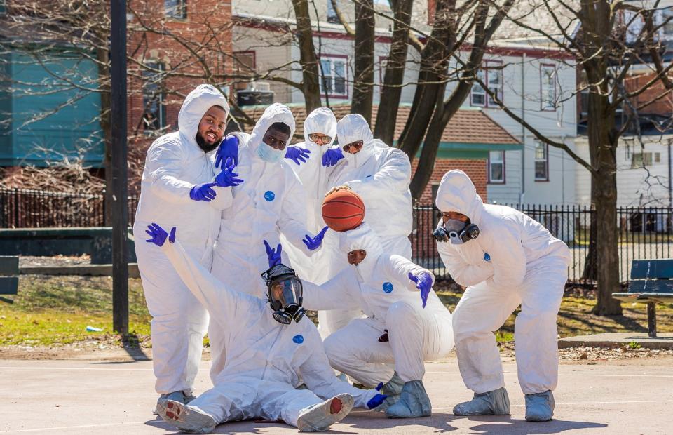 Friends Joshua Grant, Juane Mayo, DJ Huggan, Chris Mayo, Akeim Clarke, Jayvon Robinson and Tre Mayo pose for a photo after playing pickup basketball in Hazmat suits on Saturday.