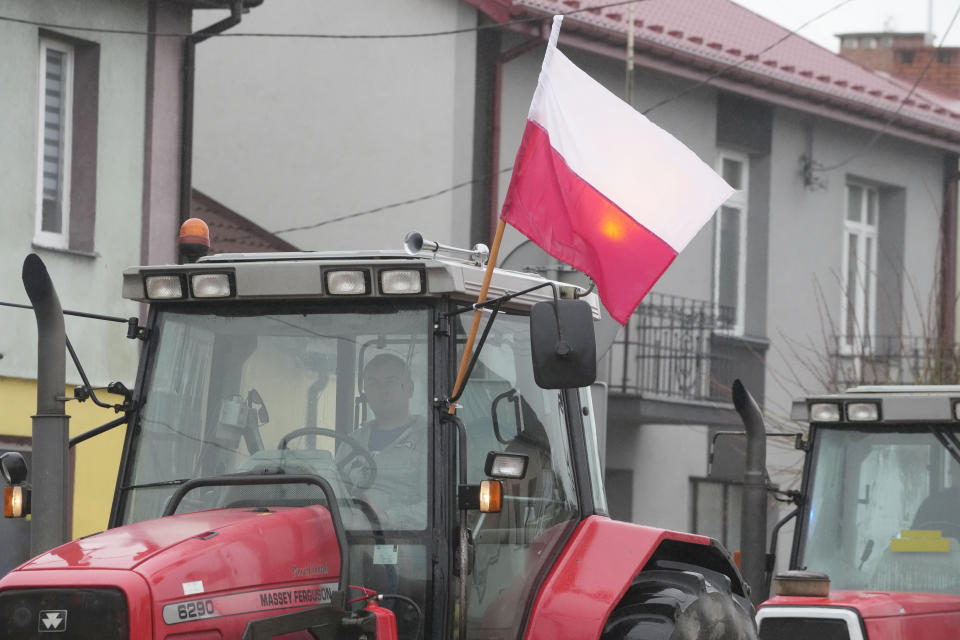 Protesting farmers in Poland are slow-driving their tractors on a road in Deblin, Poland, Wednesday, Jan. 24, 2024 to disturb traffic and draw attention to their disagreement to European Union regulations. Such protests were held across Poland. (AP Photo/Czarek Sokolowski)