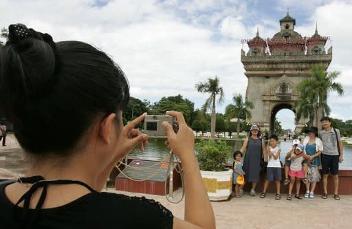 A Japanese tourist, seen here taking pictures of her family in front of the Victory Monument in Vientiane. The Association of Southeast Asian Nations (ASEAN) is working on a plan that would open the region to foreign tourists in the same way Europe's unified visa system has streamlined travel