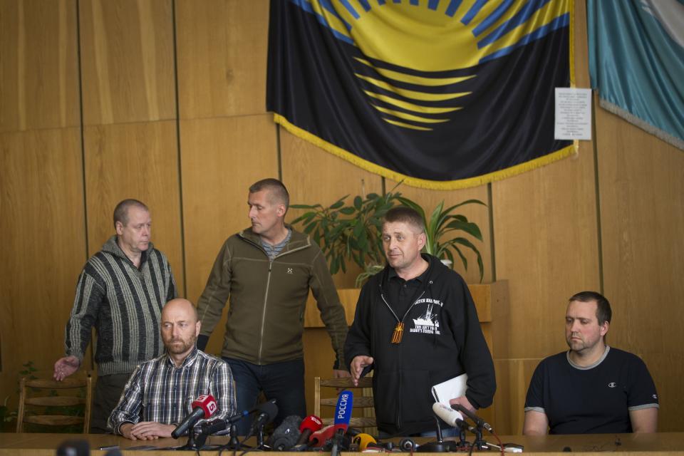 CAPTION ADDITION, ADDS ID OF MAN AT SECOND LEFT - Vacheslav Ponomarev, the self-proclaimed mayor of Slovyansk, second right, speaks, as he is surrounded by a group of foreign military observers, including Axel Schneider, second from left, who are being held by Ponomarev's group during a press conference in city hall, Slovyansk, eastern Ukraine, Sunday, April 27, 2014. As Western governments vowed to impose more sanctions against Russia and its supporters in eastern Ukraine, a group of foreign military observers remained in captivity Saturday accused of being NATO spies by a pro-Russian insurgency. The German-led, eight-member team was traveling under the auspices of the Organization of Security and Cooperation in Europe when they were detained Friday. (AP Photo/Alexander Zemlianichenko)