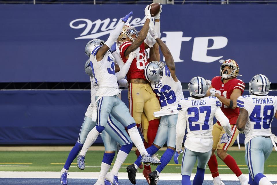 San Francisco 49ers wide receiver Kendrick Bourne (84) leaps above Dallas Cowboys' Donovan Wilson, left, and Jourdan Lewis (26) to catch a Hail Mary pass in the end zone for a touchdown in the second half of an NFL football game in Arlington, Texas, Sunday, Dec. 20, 2020. (AP Photo/Michael Ainsworth)