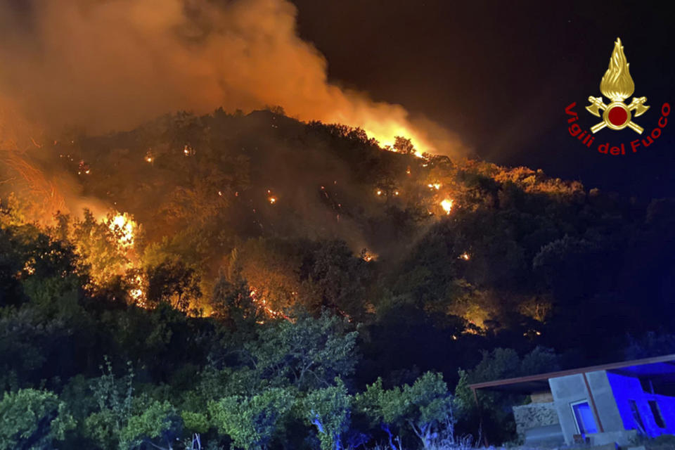 Flames burn in the vegetation near Curcuraci, Messina, in Sicily, southern Italy, late Monday, July 24, 2023. Firefighters confronted blazes Monday in southern Italy, where people have sweltered through weeks of temperatures in the high 30s Celsius (over 100 F) and mid-40s Celsius (113 F and up.) (Italian Firefighters via AP)