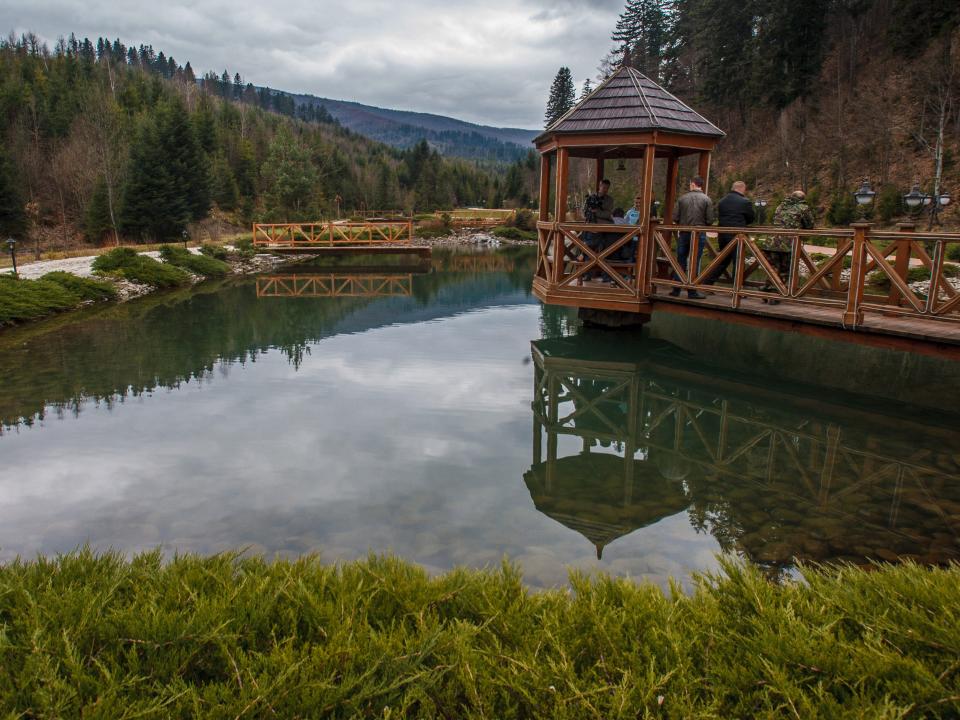 People stand on a bridge over an artificial lake on Medvedchuk's dacha property.