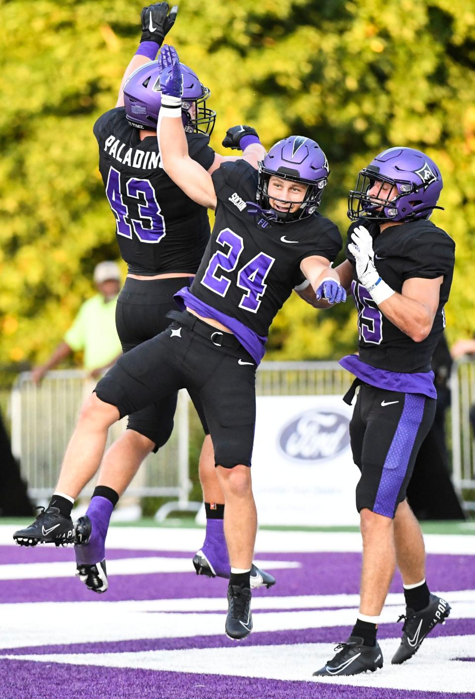 Furman Paladins cornerback Cally Chizik (24) celebrates with teammate Furman Paladins linebacker Braden Gilby (43) and Furman Paladins safety Jack Rhodes (15) after scoring against North Greenville Crusaders at Paladin Stadium in Greenville, Thursday, September 1, 2022.