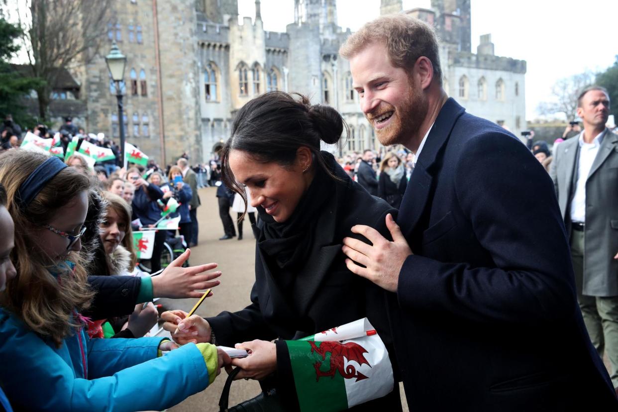 Prince Harry and his fiancee Meghan Markle sign autographs and shake hands with children as they arrive to a walkabout at Cardiff Castle: Chris Jackson/Getty Images