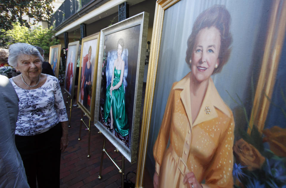 FILE - Former Virginia first lady Virginia "Jinks" Rogers Holton, left, admires a portrait of her predecessor, Katherine Godwin, right, after official portraits of the 10 living former first ladies were unveiled at the Executive Mansion in Richmond, Va., on Sept. 10, 2012. Holton died Friday, Dec. 16, 2022, at her home, her family said in a statement. She was 97. (Bob Brown/Richmond Times-Dispatch via AP, File)