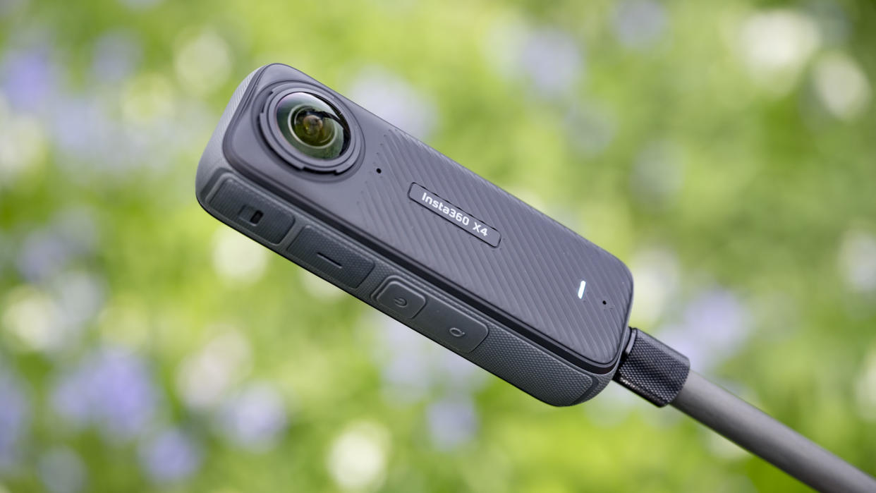  Insta360 X4 360 degree camera outdoors with vibrant grassy background. 