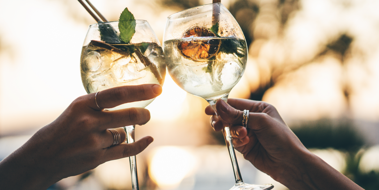 two people toasting cocktails