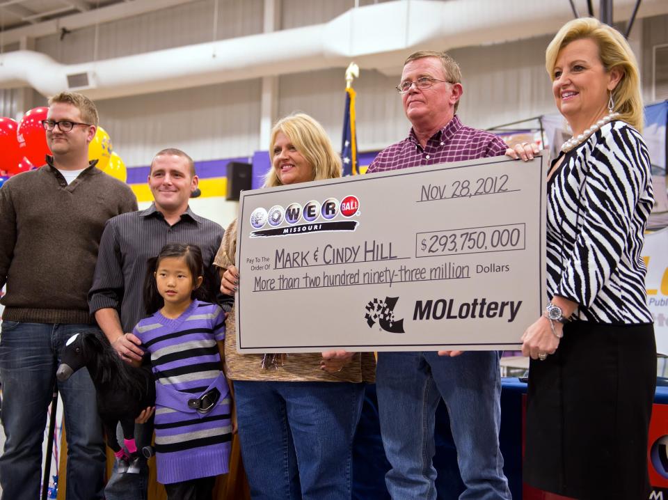 Cindy and Mark Hill, center and second from right, stand with a ceremonial check from the Missouri Lottery for $293,750,000 during the news conference, Friday, November 30, 2012