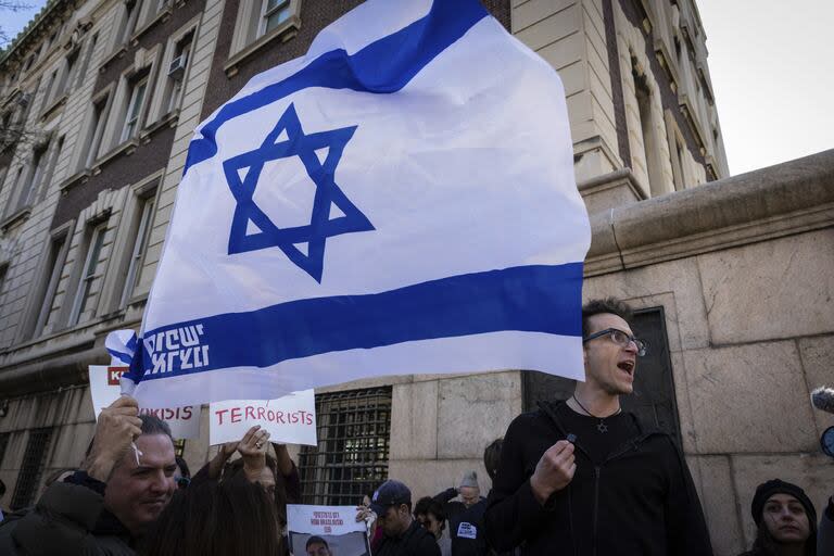 El profesor adjunto de la Universidad de Columbia, Shai Davidai, lee los nombres de los rehenes israelíes retenidos por Hamas tras serle denegado el acceso al campus principal, para impedirle acceder al césped ocupado actualmente por manifestantes estudiantiles pro Palestina, en Nueva York, el lunes 22 de abril de 2024. 