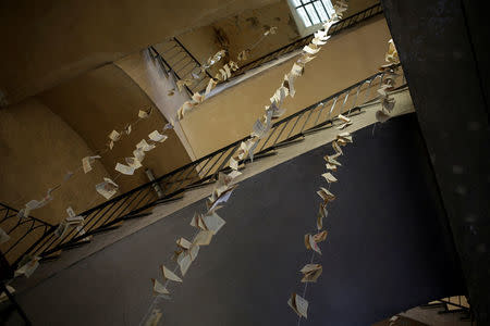A view shows pages from books hanging at the main stairway of the Cavallerizza Reale building, which is occupied by the "Assemblea Cavallerizza 14:45" movement in Turin, Italy, July 15, 2016. REUTERS/Marco Bello