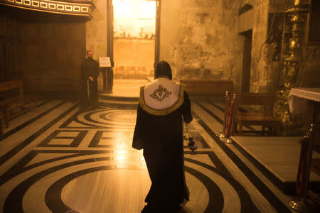 An Orthodox Christian priest walks inside the Church of the Holy Sepulchre in Jerusalem's Old City November 3, 2017. REUTERS/Ronen Zvulun