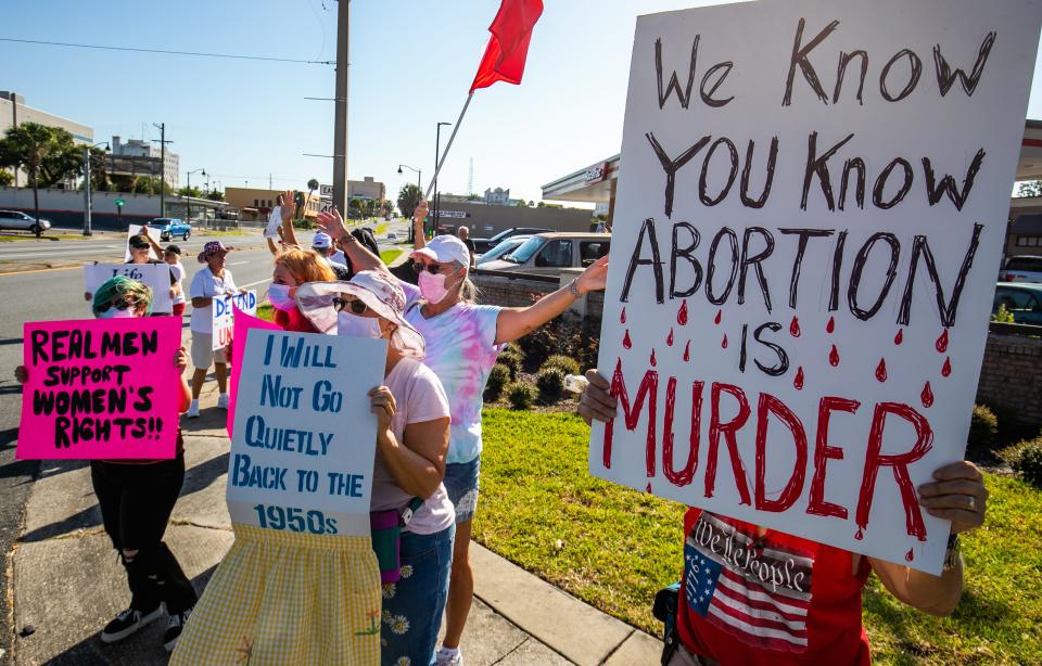 In this file photo from Oct. 2, 2021, abortion rights supporters, left, and anti-abortion activists, right, rallied against each other. The Supreme Court overturned Roe v. Wade on Friday, eliminating a constitutional right to an abortion.