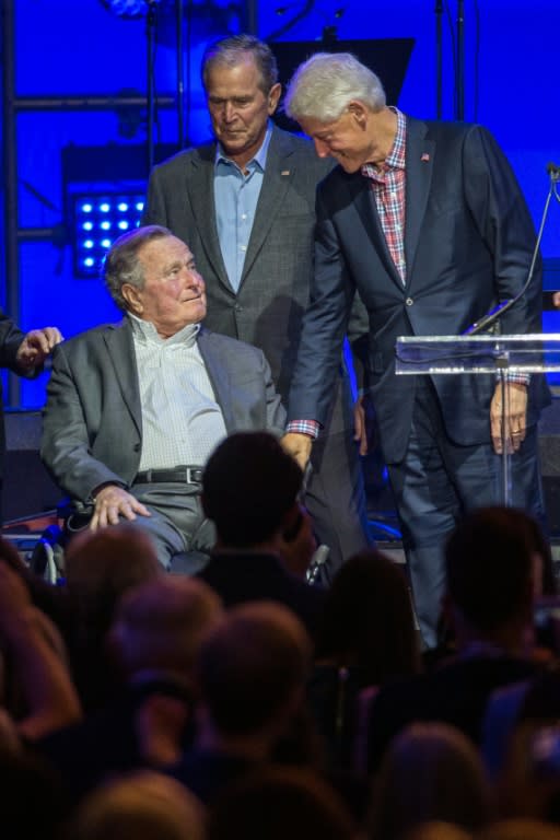 Former US President Bill Clinton, with President George W. Bush (C), greets President George H. W. Bush during the Hurricane Relief concert in College Station, Texas, on October 21, 2017