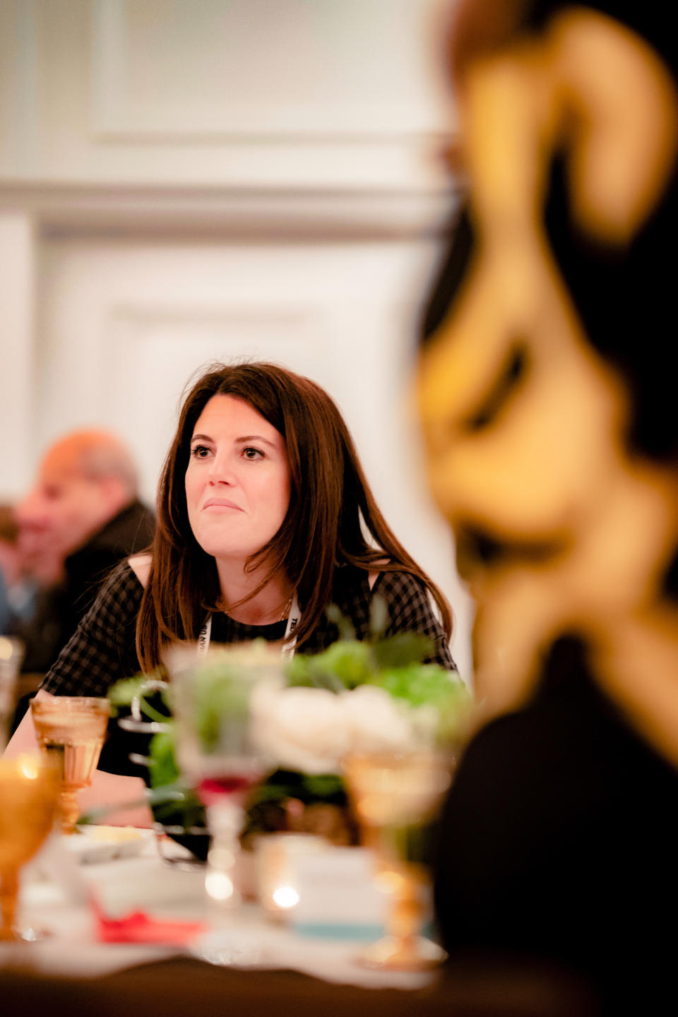 Lewinsky sits at a table during a dinner