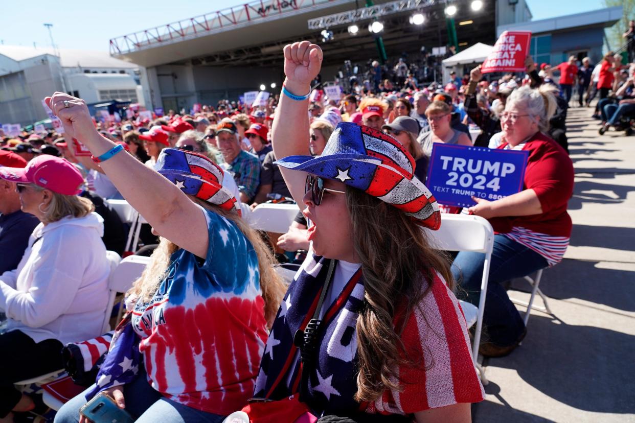 Alicia Wesolek, right, of Saginaw and Janice Hammond, of Freeland, cheer on a speaker during a rally for Donald Trump at Avflight Saginaw in Freeland on Wednesday, May 1, 2024.