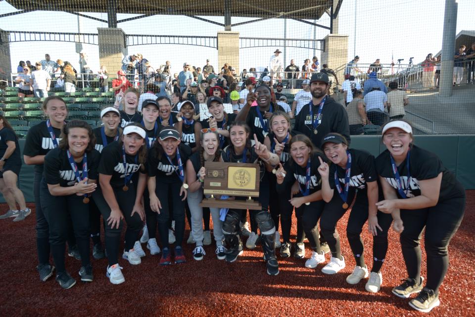 The Topeka High softball team celebrates with their KSHSAA Class 6A State Championship trophy Friday after defeating Washburn Rural 2-1.