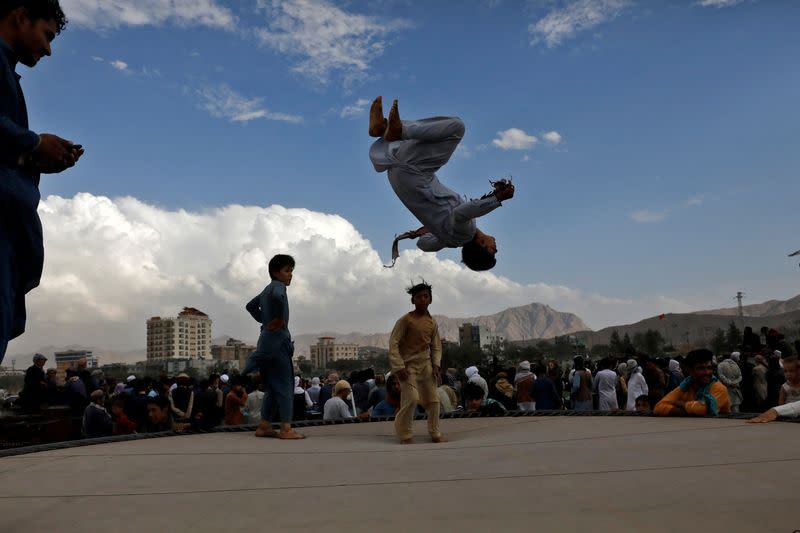 Children jump on a trampoline at the Chaman-e-Huzori field in Kabul