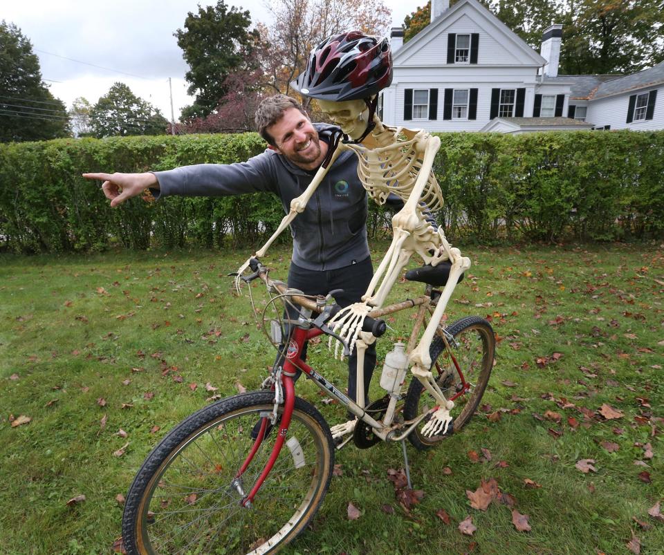 Aaron Berlin pretends to teach a skeleton how to ride a bike as part of his Halloween decor on Summer Street in Kennebunk as he and his family gear up for trick-or-treaters.